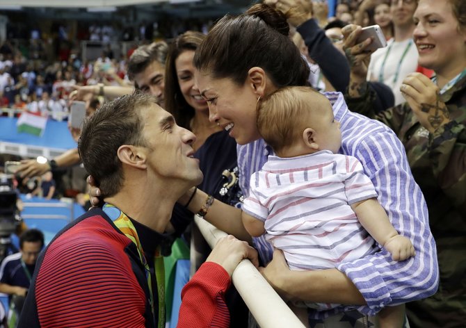 „Scanpix“/AP nuotr./Michaelą Phelpsą laimėjus dar vieną aukso medalį sveikina Nicole Johnson ir jų sūnus Boomeris