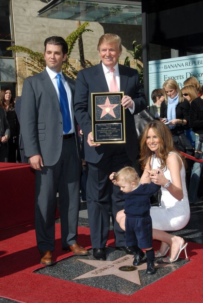 Vida Press nuotr./Donaldas Trumpas su vyriausiu sūnumi Donaldu jaunesniuoju, žmona Melania ir jauniausiu sūnumi Barronu (2007 m.)