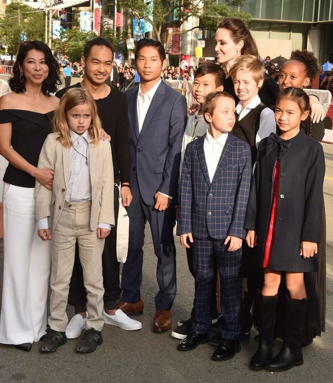 AFP/„Scanpix“ nuotr./Angelina Jolie su Loung Ung (kairėje), savo vaikais ir mažąja aktore Sareum Srey Moch (dešinėje). Vivienne – su šviesiu kostiumu