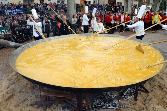 AFP/„Scanpix“ nuotr./Pietų Prancūzijoje per Velykas 15 tūkst. kiaušinių yra įmušami į didžiulę keptuvę ir juos maišant kartimis iškepamas milžiniškas omletas.
