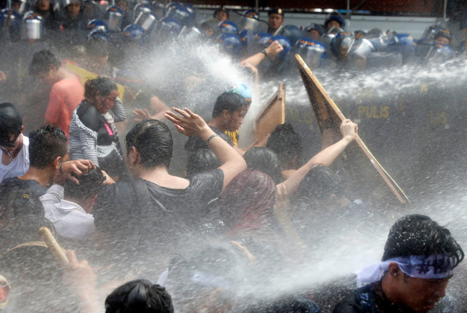 „Reuters“/„Scanpix“ nuotr./Prieš D.Trumpą nusiteikę protestuotojai Maniloje išvaikyti vandens patrankomis
