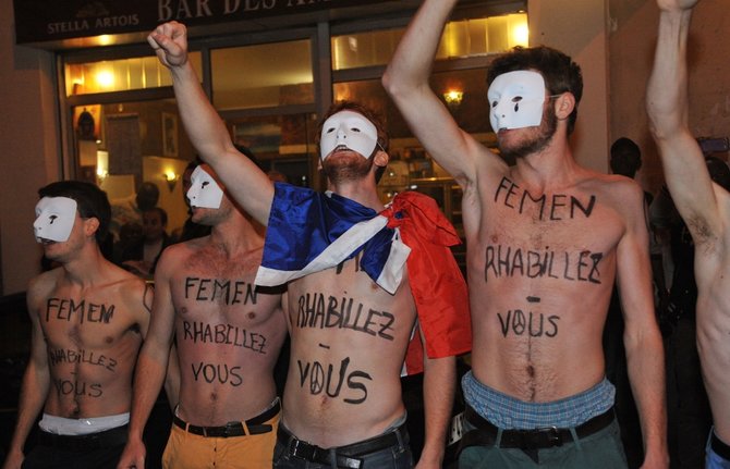 AFP/„Scanpix“ nuotr./Tai ne gėjų eitynės, o vienalyčių santuokų priešininkų akcija. Judėjimo Hommen nariai protestuoja prie feminisčių organizacijos Femen būstinės Paryžiuje