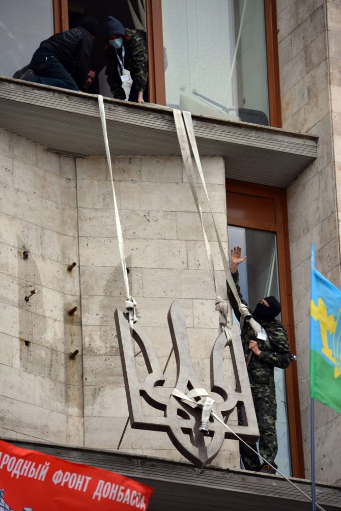AFP/„Scanpix“ nuotr./Donecke separatistai nuo srities administracijos pastato nukabino Ukrainos herbą