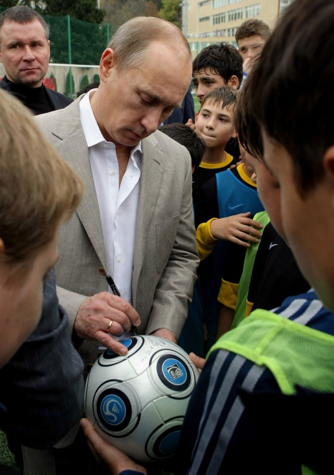 AFP/„Scanpix“ nuotr./Vladimiras Putinas pasirašo ant futbolo kamuolio