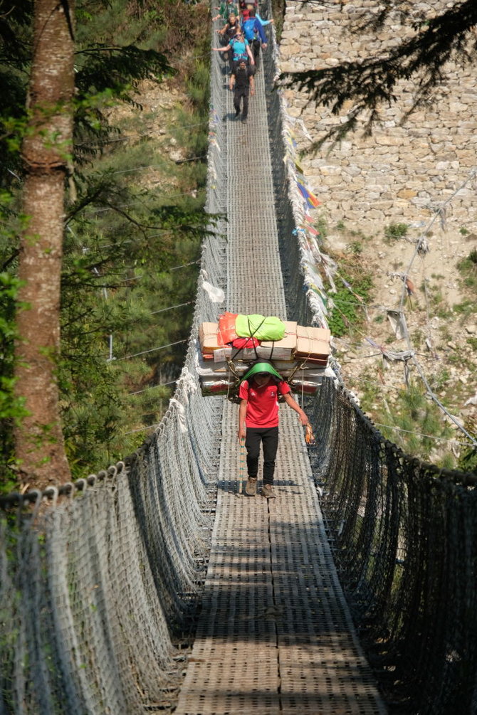 Ievos Bašarovienės nuotr./Siaurais kalnų takeliais, į stačias įkalnes, per vėjyje siūbuojančius tiltus – taip ant nešikų pečių atkeliauja ir turistams skirtas maistas bei gėrimai