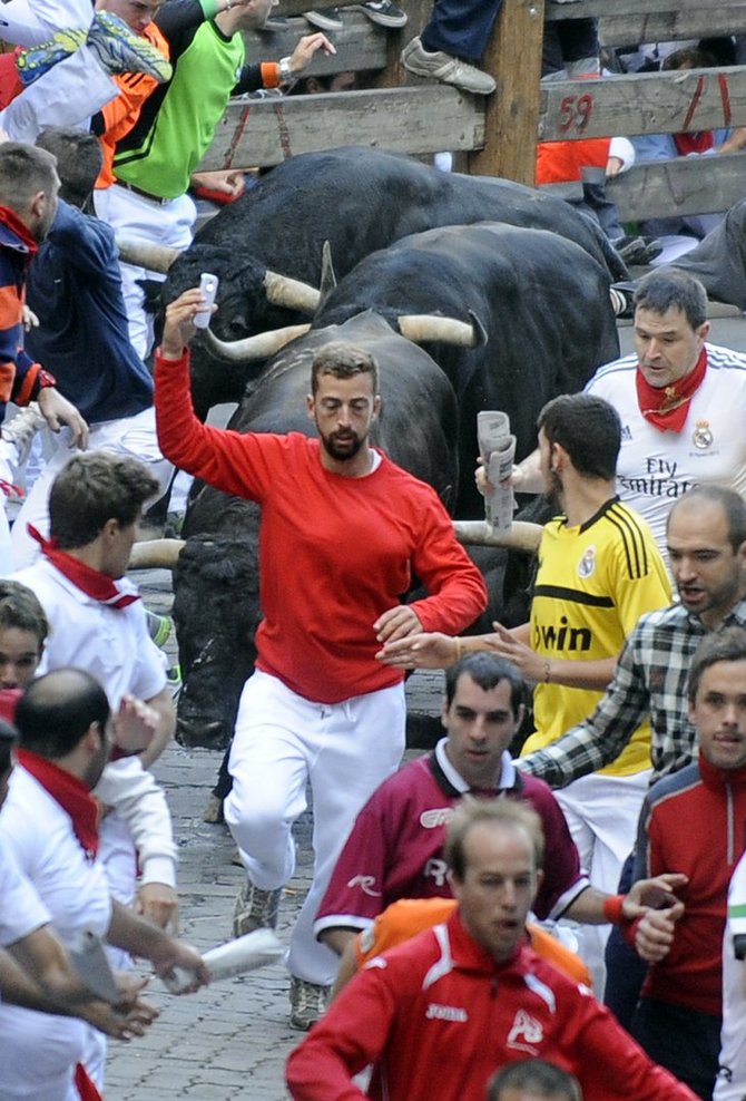 AFP/„Scanpix“ nuotr./Britas, besidarantis asmenukę per bėgimą nuo bulių