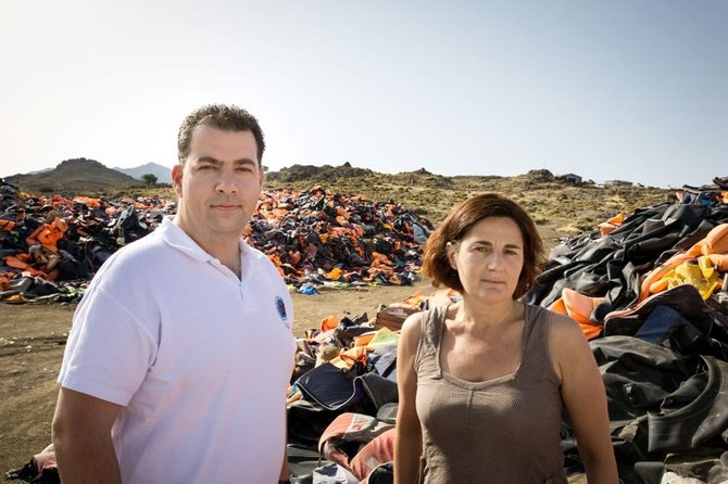 UNHCR nuotr./Nanseno pabėgėlių apdovanojimo laureatai – E.Latsoudi ir K.Mitragas – stovi Lesbo salos šiaurinėje pakrantėje. Jiems už nugarų – didžiulės, 5 m. aukščio gelbėjimo liemenių stirtos, nusėjusios 4 ha teritoriją, primenančios 2015 m. pabėgėlių krizės mastą Graikijos pakrantėse.