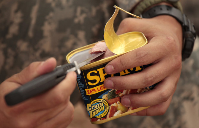 „Reuters“/„Scanpix“ nuotr./JAV armijos karys atidaro konservuotos mėsos dėžutę