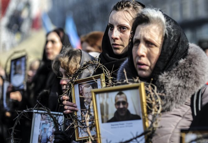 AFP/„Scanpix“ nuotr./Moterys laiko Maidane žuvusių vyrų portretus