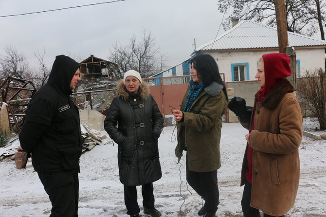 Savanoriai iš Charkovo ir moteris (antra iš kairės), gyvenanti per 20 metrų nuo fronto linijos Marjinkoje
