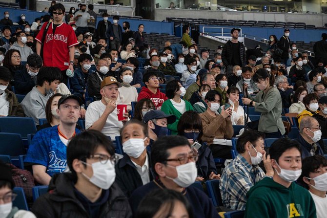 AFP/„Scanpix“ nuotr./Japonijoje sporto varžybose žmonės dėvi kaukes