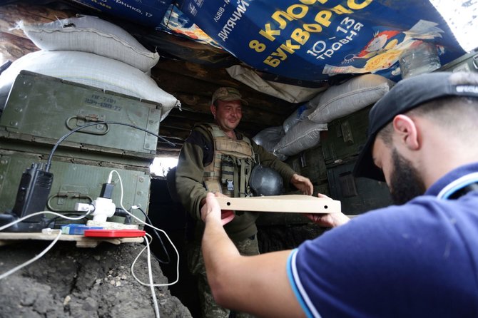 AFP/„Scanpix“ nuotr./Ukrainos karo veteranai maitina kareivius karštuosiuose taškuose