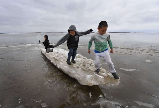 AFP/„Scanpix“ nuotr./Eskimų vaikai žaidžia ant tirpstančio ledo