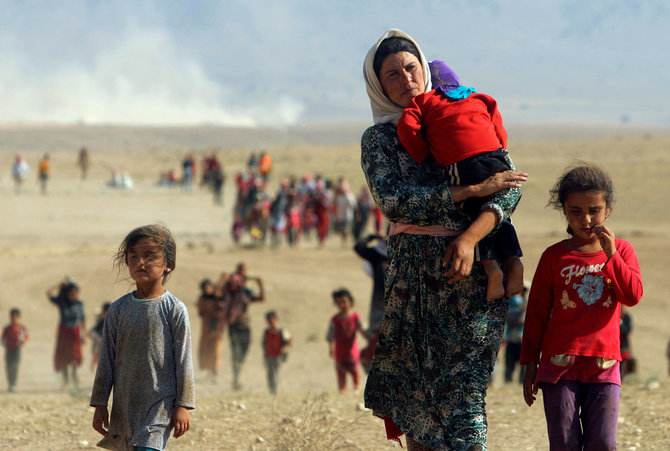 „Reuters“/„Scanpix“ nuotr./Irakas, 2014 rugpjūčio 11 d. Jazidai pabėgėliai palieka Islamo valstybės kovotojų užgrobtą Sindžaro miestą ir keliauja link sienos su Sirija
