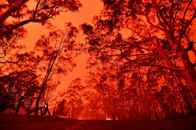 AFP/„Scanpix“ nuotr./Australijoje šėlstantys gaisrai paplūdimiuose įkalino tūkstančius žmonių