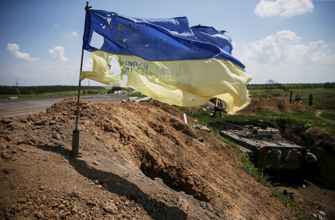 „Reuters“/„Scanpix“ nuotr./Apiplėšyta Ukrainos vėliava prie Marijankos miesto žyminti ukrainiečių kariuomenės kontroliuojamą teritoriją