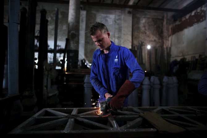 „Reuters“/„Scanpix“ nuotr./Jorge Fajardo dirba suvirintoju gamykloje