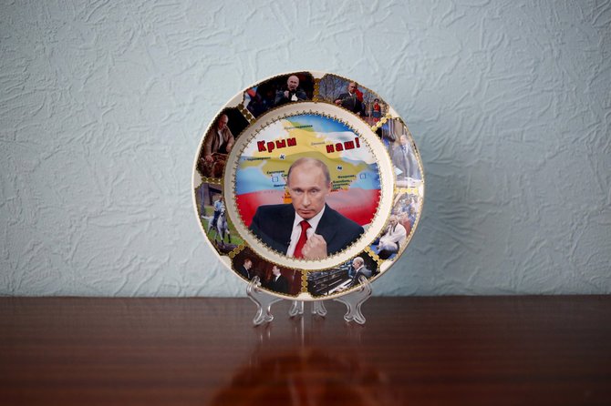 „Reuters“/„Scanpix“ nuotr./Kazanės viešbučio kambaryje fotografuoti siuvenyrai su Putino veidu