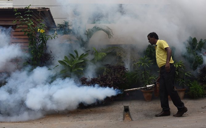 AFP/„Scanpix“ nuotr./Indijos sostinė purškiama priemone nuo uodų pernešančių dengės virusą