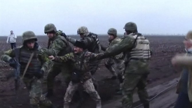 „Reuters“/„Scanpix“ nuotr./Krymo kariškis bando sulaikyti Ukrainos specialiąsias pajėgas atvykusias į sprogdinimo vietą 
