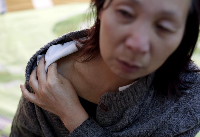 „Reuters“/„Scanpix“ nuotr./Cui Wenlan rodo sužeidimą ant peties