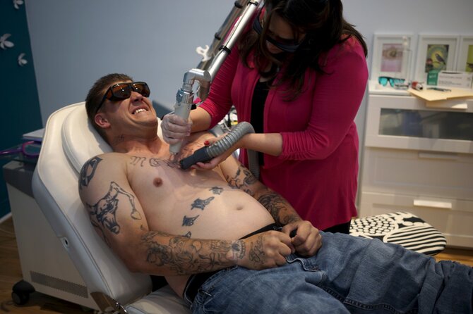 „Reuters“/„Scanpix“ nuotr./Programos dalyviui lazeriu šalinama tatuiruotė