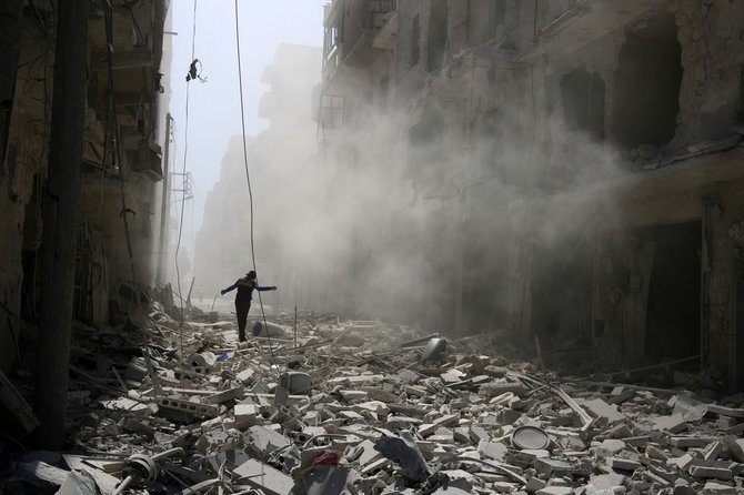 „Reuters“/„Scanpix“ nuotr./Vyras vaikšto tarp griuvėsių Alepo mieste Sirijoje