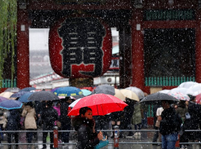 „Reuters“/„Scanpix“ nuotr./Tokijuje pirmąkart per 54 metus lapkritį iškritęs sniegas sutrikdė eismą