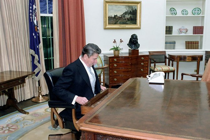 „Reuters“/„Scanpix“ nuotr./Ronaldas Reaganas savo darbo vietoje