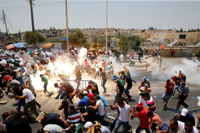 „Reuters“/„Scanpix“ nuotr./Į protestuojančius palestiniečius mestas ašarinių dujų užtaisas Jeruzalėje