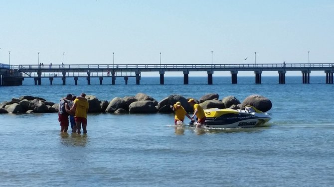 15min skaitytojo nuotr./Išgelbėtą ukrainietį laiko Palangos gelbėtojų vadas J.Pirožnikas su kolega