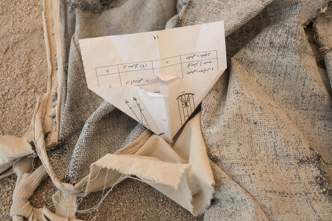  Joël van Houdt nuotr./Moksleivių padarytas popierinis lėktuvėlis tarp palapinėje sustatytų suolų