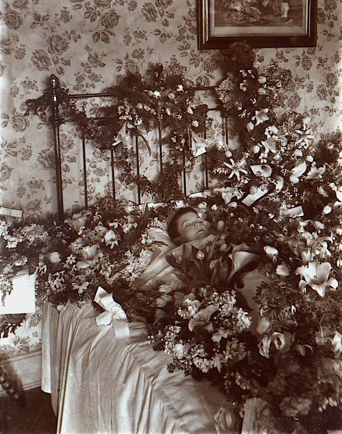 Wikimedia Commons nuotr./Miręs vaikas tarp gėlių