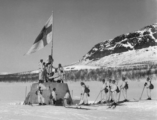 Wikimedia Commons / Public Domain nuotr./Suomijos kariai iškelia vėliavą Norvegijos, Švedijos ir Suomijos sienų susikirtimo taške karo pabaigoje