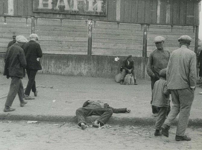 Wikimedia Commons / Public Domain nuotr./Nuo bado miręs žmogus ir jį apeinantys praeiviai Charkive, 1932 m.