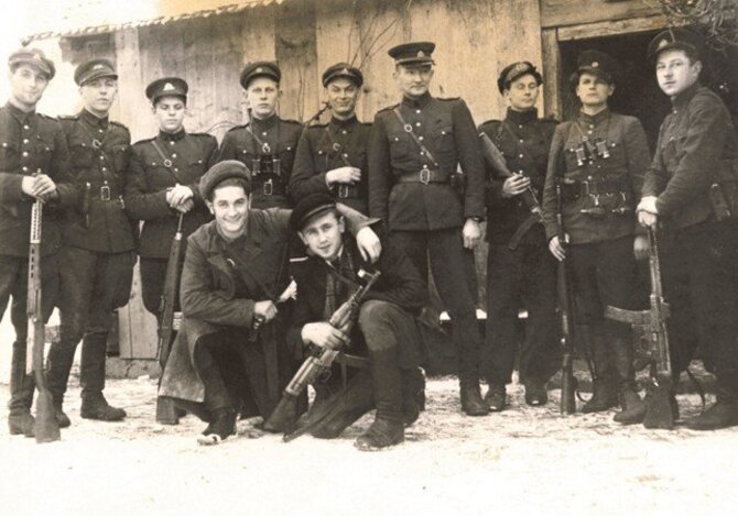Okupacijų ir laisvės kovų muziejaus nuotrauka/Partizanų vadovybės įgaliotiniai ryšiams su Vakarais Juozas Lukša-Skrajūnas ir Kazimieras Pyplys-Audronis (pritūpę) su juos į žygį išlydinčiais Tauro apygardos partizanais. Antroje eilėje iš kairės: Žalgirio rinktinės štabo Spaudos ir informacijos skyriaus viršininkas Aleksandras Grybinas-Faustas, š