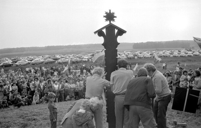 Fotografijos autorius – Andrius Petrulevičius./Baltijos kelio akcijos metu grupė žmonių stato koplytstulpį su datomis „1939–1989“. Kairėje stovi architektas Algimantas Nasvytis. LCVA fondų nuotrauka. 