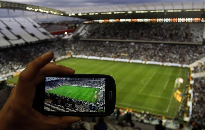 Scanpix nuotr./Išmaniuoju telefonu fotografuojamas futbolo stadionas