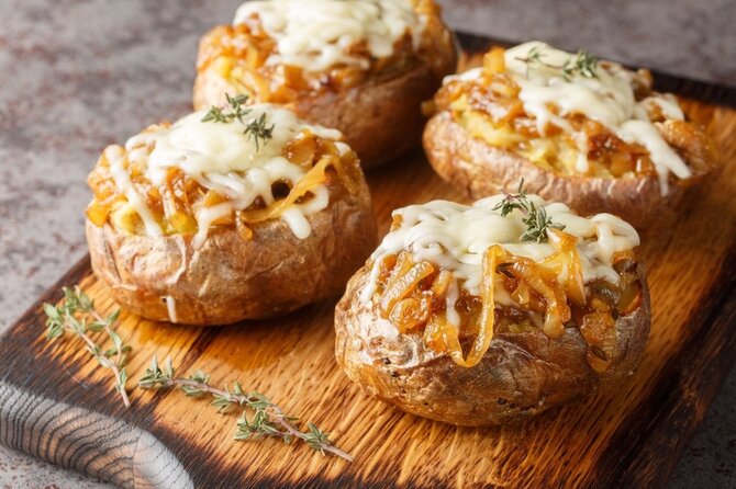 Shutterstock nuotr./Įdarytos šviežios bulvės su sūriu ir daržovėmis.