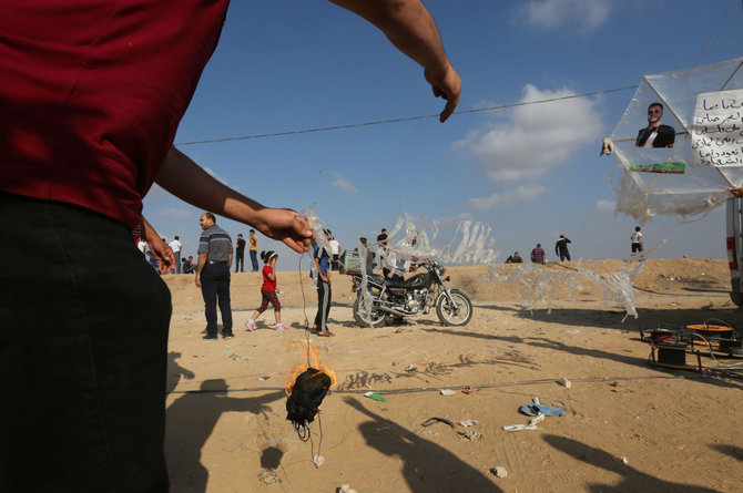 AFP/„Scanpix“ nuotr./Palestiniečiai iš Gazos Ruožo leidžia padegamuosius aitvarus į Izraelio teritoriją