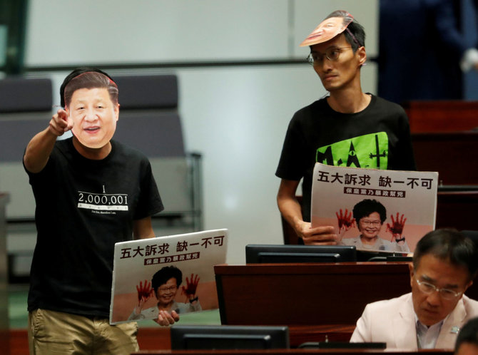 „Reuters“/„Scanpix“ nuotr./Deputatas Honkonge su Xi Jinpingo kauke