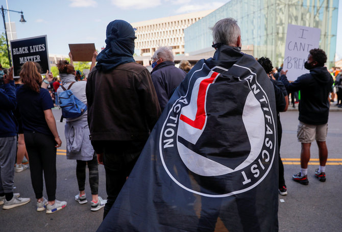 „Reuters“/„Scanpix“ nuotr./Protestuotojas su „Anti-Fascist Action“ vėliava Bostone