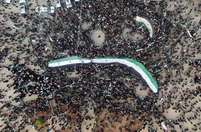 „Reuters“/„Scanpix“ nuotr./Sirijoje minint pilietinio karo dešimtmetį Idlibe į gatves išėjo tūkstančiai demonstrantų