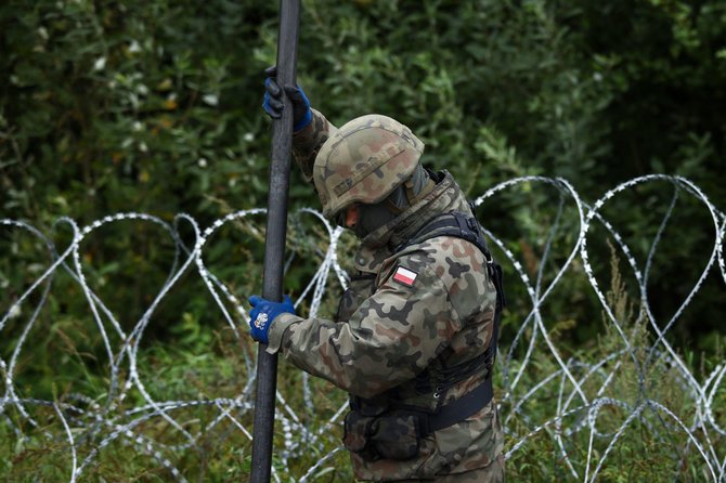 AFP/„Scanpix“ nuotr./Lenkijos kariai stato pjaunančios vielos tvorą migrantams sulaikyti