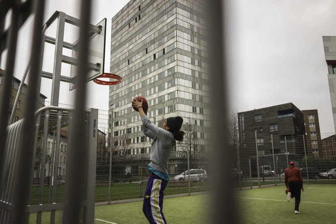 Beno Gerdžiūno nuotr./Paaugliai žaidžia krepšinį Molenbeke, o už jų stovi vienas iš daugybės socialinių būstų