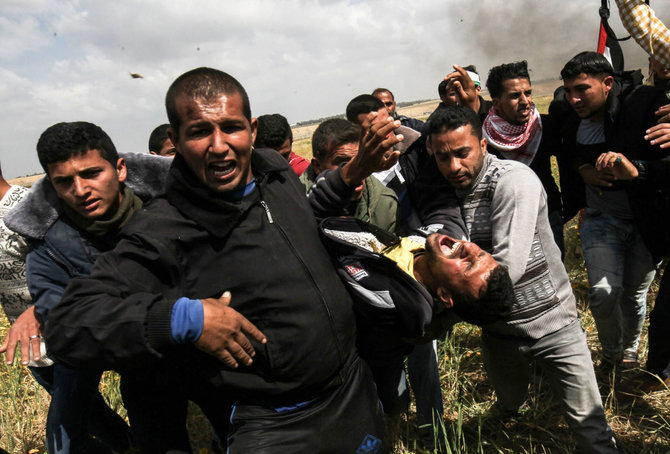 AFP/„Scanpix“ nuotr./F.al Raqibas (priekyje, pačioje kairėje) neša vieną sužeistąjį