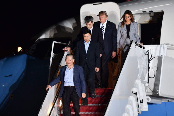 AFP/„Scanpix“ nuotr./Paleisti amerikiečiai nusileido JAV, kur juos pasitiko D.Trumpas