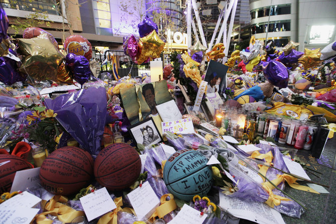 „Scanpix“/AP nuotr./Prie „Staples Center“ arenps žmonės neša įvairius daiktus Kobe Bryanto atminimui.