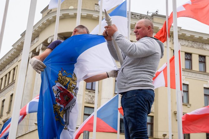 „Scanpix“ nuotr./Latvijoje darbuotojai nukabino IIHF vėliavą.