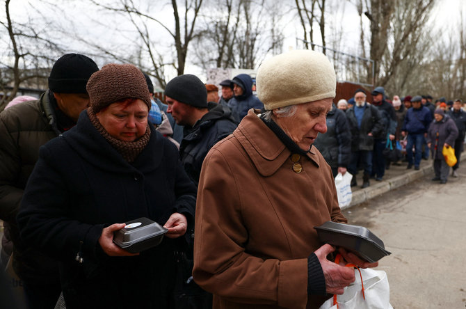 „Reuters“/„Scanpix“ nuotr./Chersono žmonėms dalijamas maistas (2023 m. vasario 22 d., Ukraina)